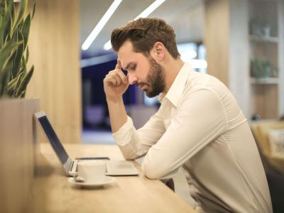 Man at table looking at laptop, Cyberscore, cybersecurity companies Chicago
