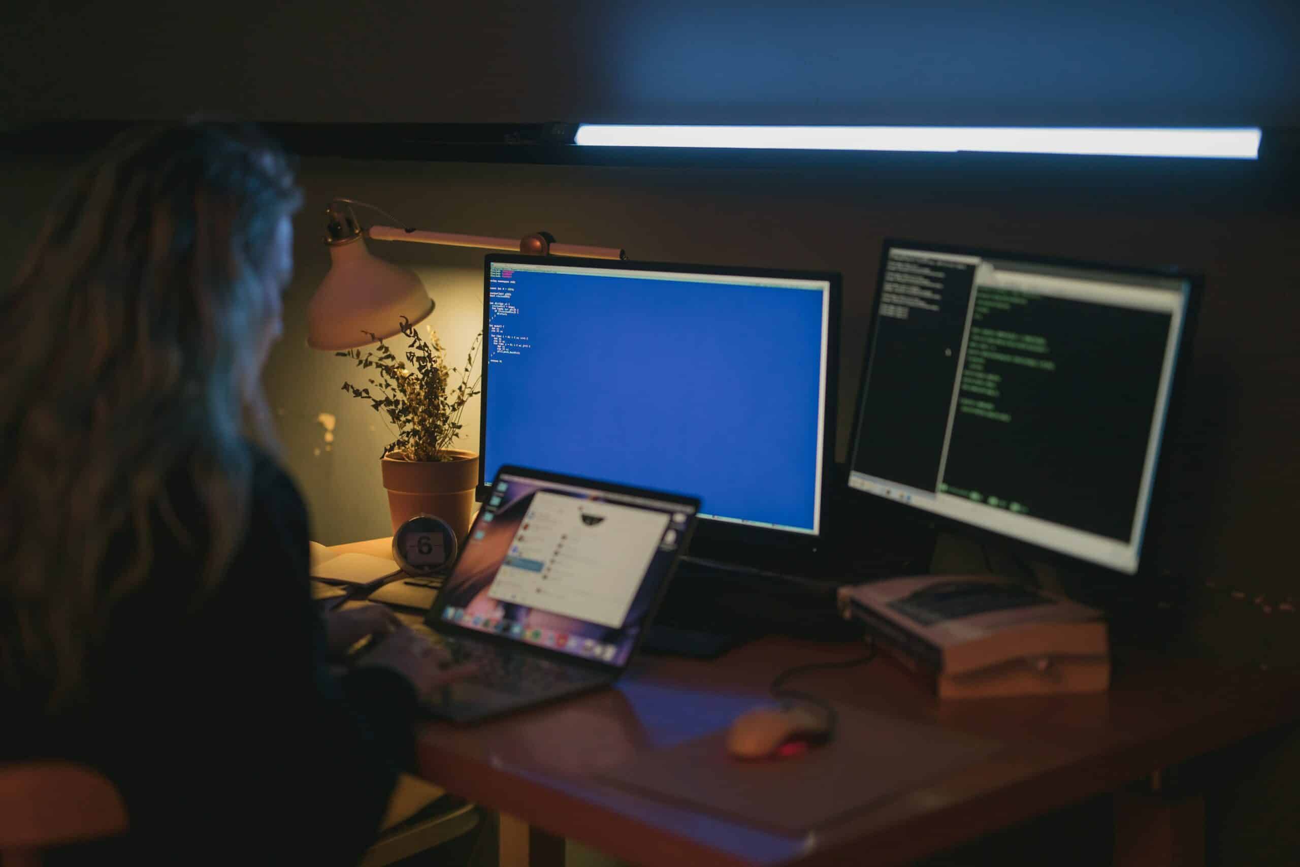 Person on laptop in dark room, Cybersecurity, Ransomware Protection