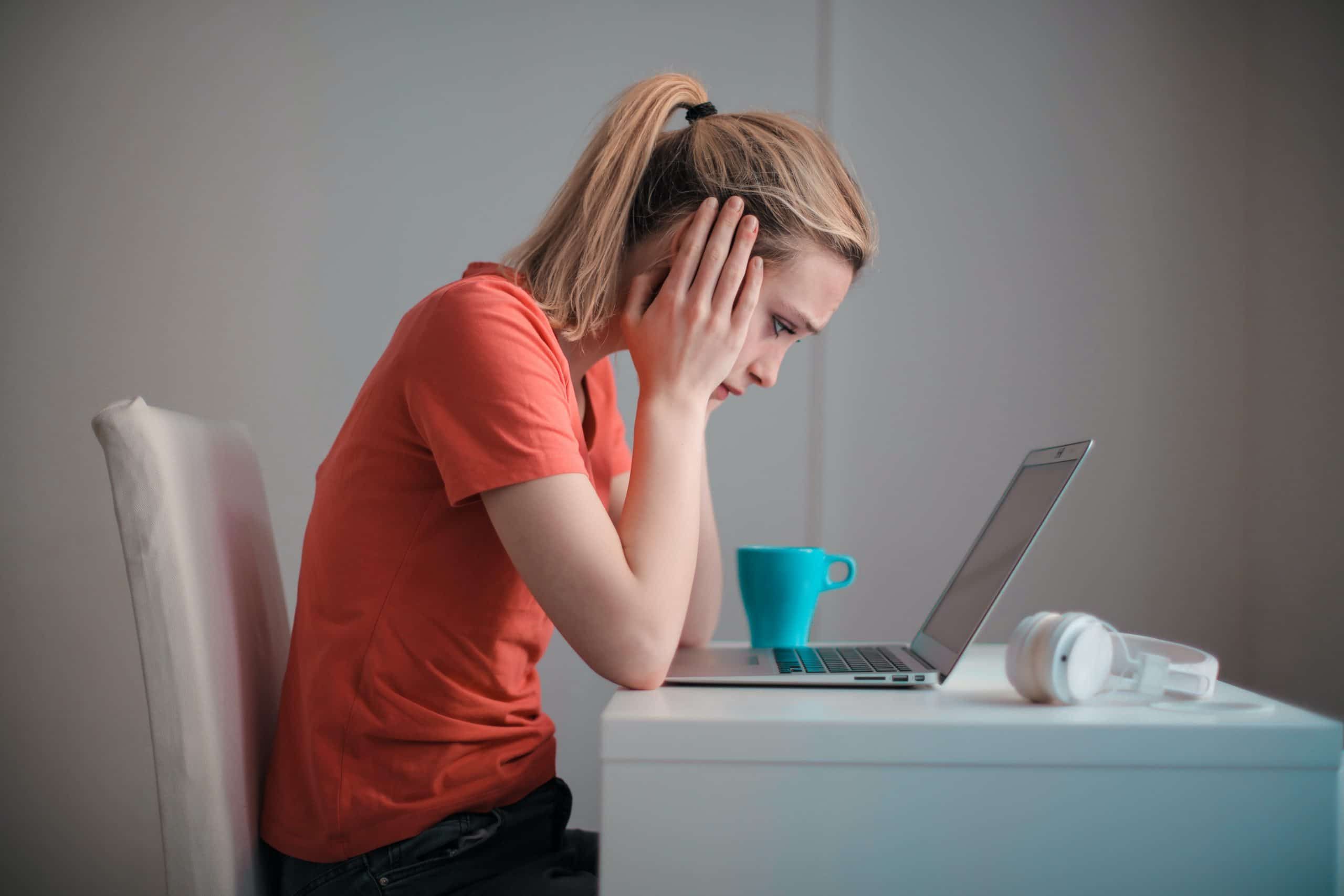 girl sitting at table looking at laptop, Cyberscore, cybersecurity companies Chicago
