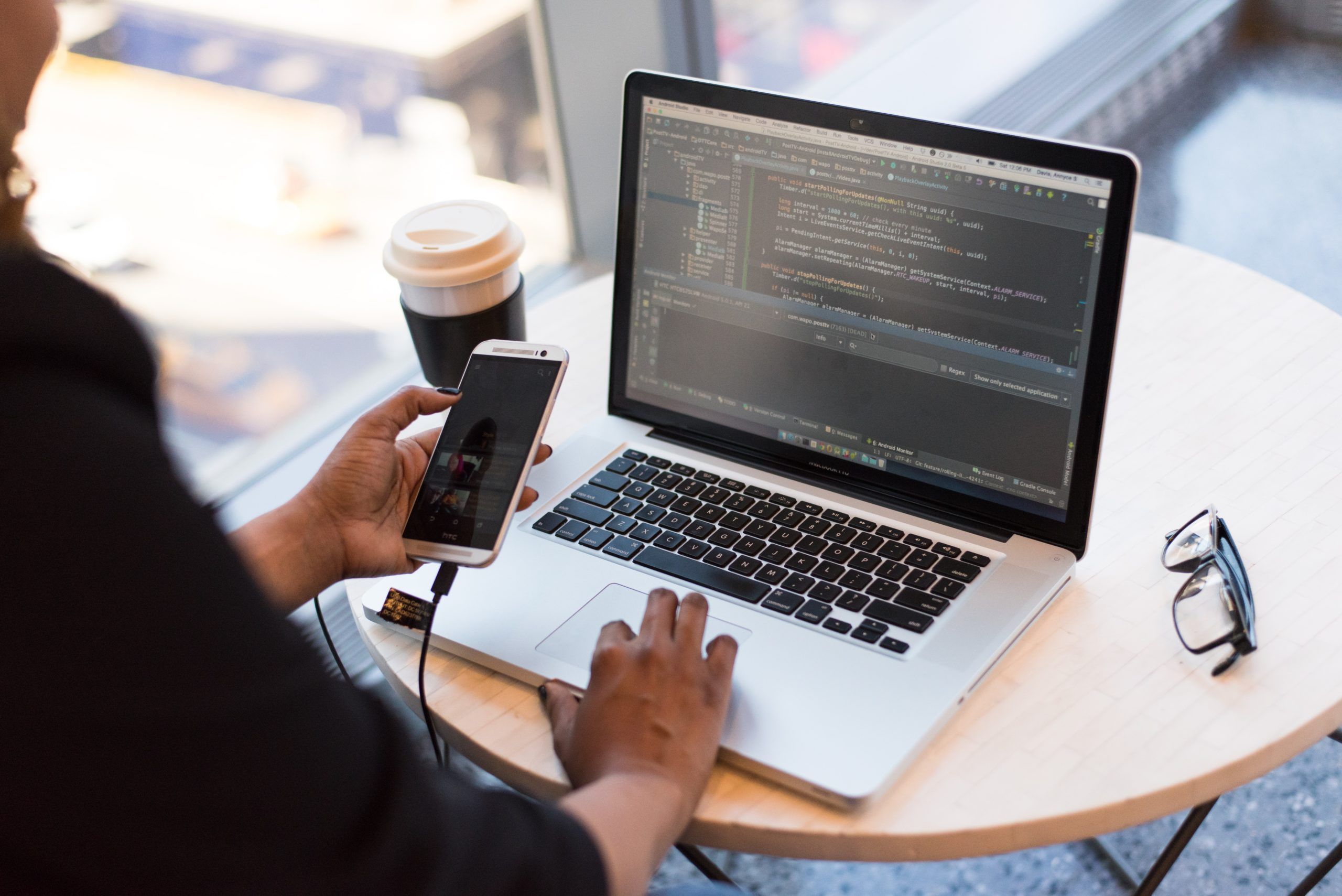person sitting at table with laptop and phone, Cyberscore, cybersecurity companies Chicago