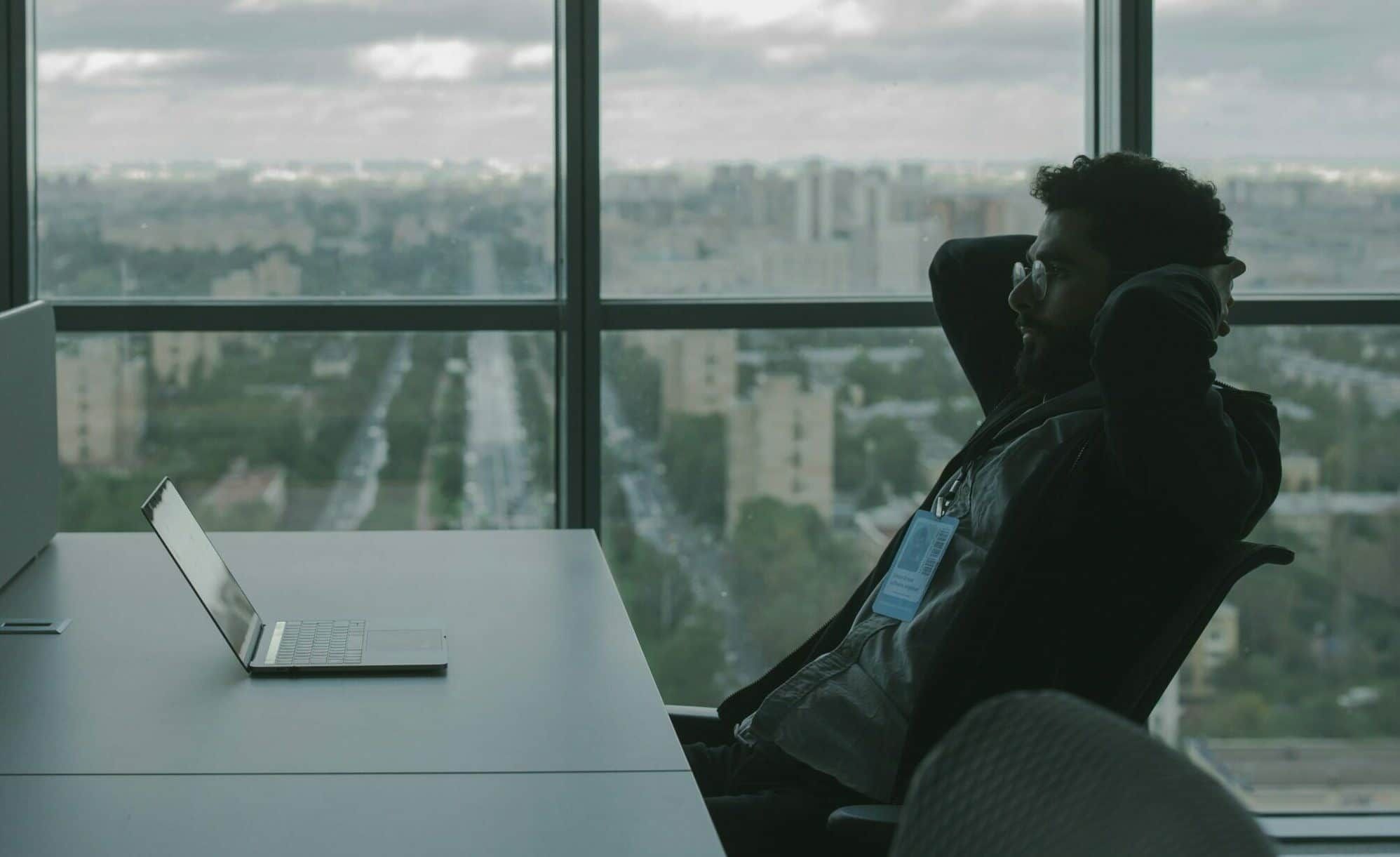 Person sitting at a desk - IT Guy vs Cybersecurity Provider, Cyberscore, cybersecurity companies Chicago
