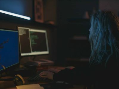 Person in dark room on computer, Cybersecurity, Ransomware Protection