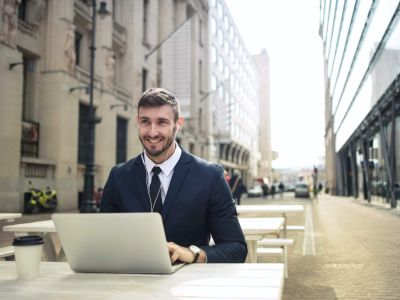 Man on laptop outside of office buildings, Cyberscore, cybersecurity companies Chicago