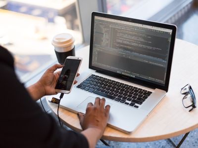person sitting at table with laptop and phone, Cyberscore, cybersecurity companies Chicago