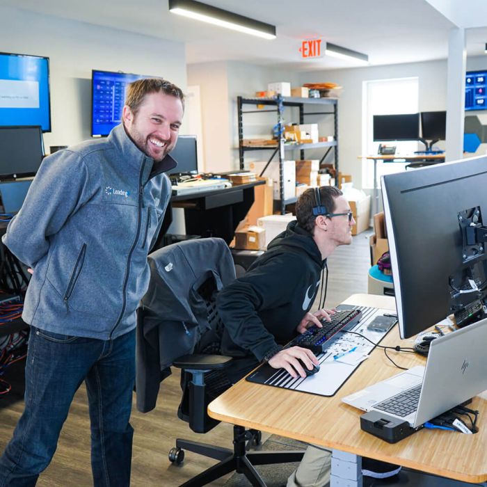 LeadingIT CEO Stephen smiles to the camera while a technician works on their computer